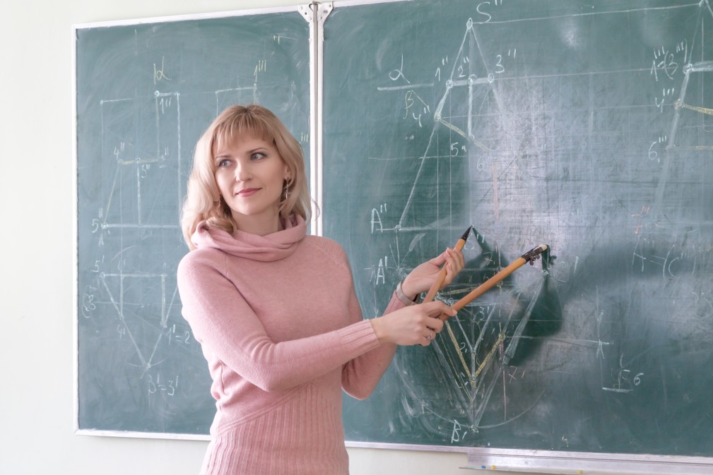 teacher-stands-at-the-blackboard-and-explains-to-the-students-a-new-topic-on-descriptive-geometry